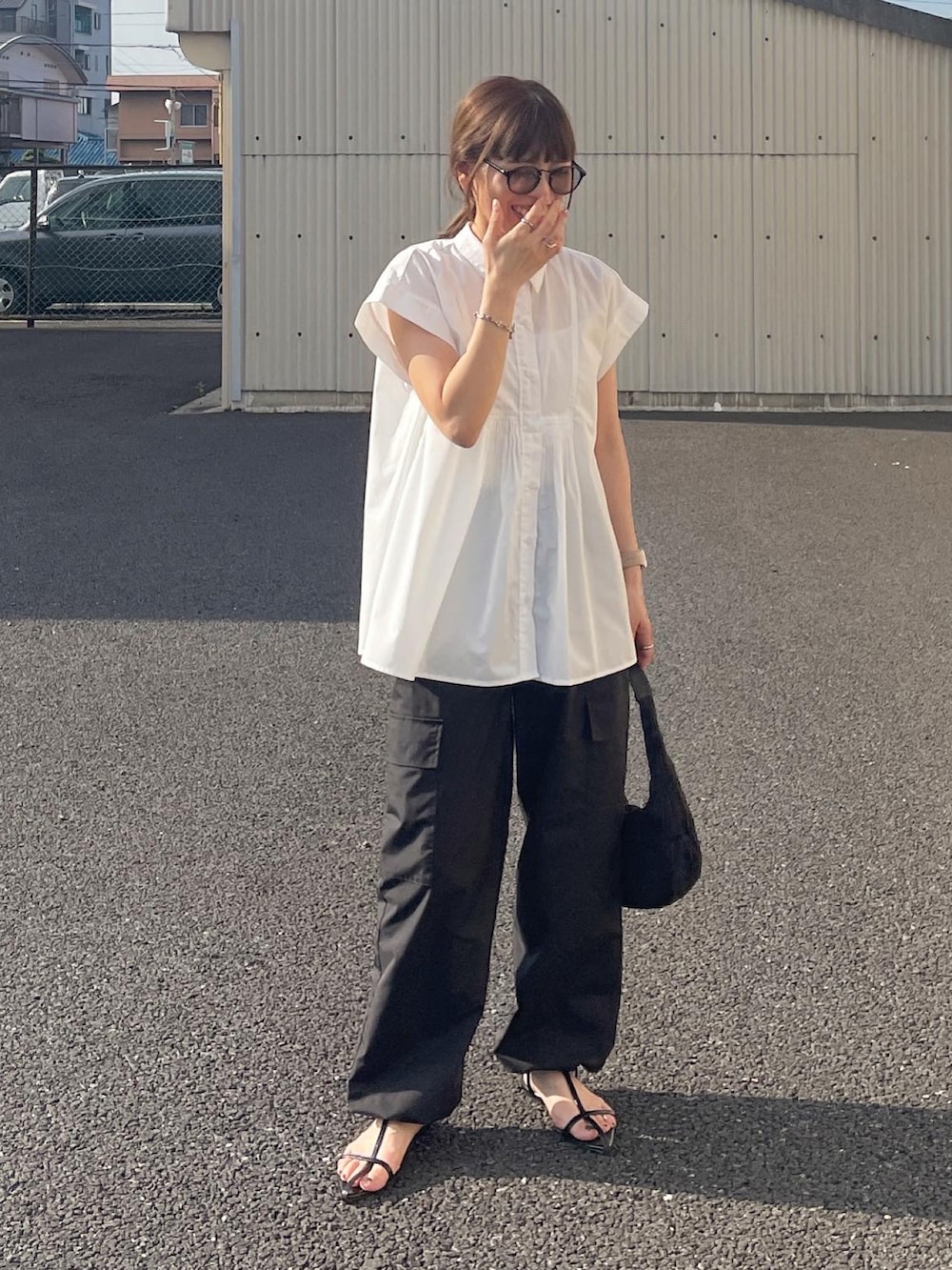 ホワイト系のシャツ/ブラウス、ブラック系のカーゴパンツ、ブラック系のハンドバッグを着用したレディースの夏コーディネートの2枚目の写真