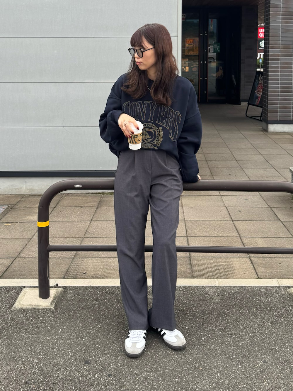 ブルー系のスウェット、グレー系のスラックス、ホワイト系のスニーカーを着用したレディースの秋コーディネートの2枚目の写真