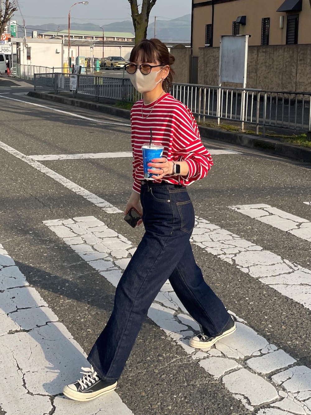 レッド系のTシャツ/カットソー、ブルー系のデニムパンツを着用したレディースの春コーディネートの5枚目の写真