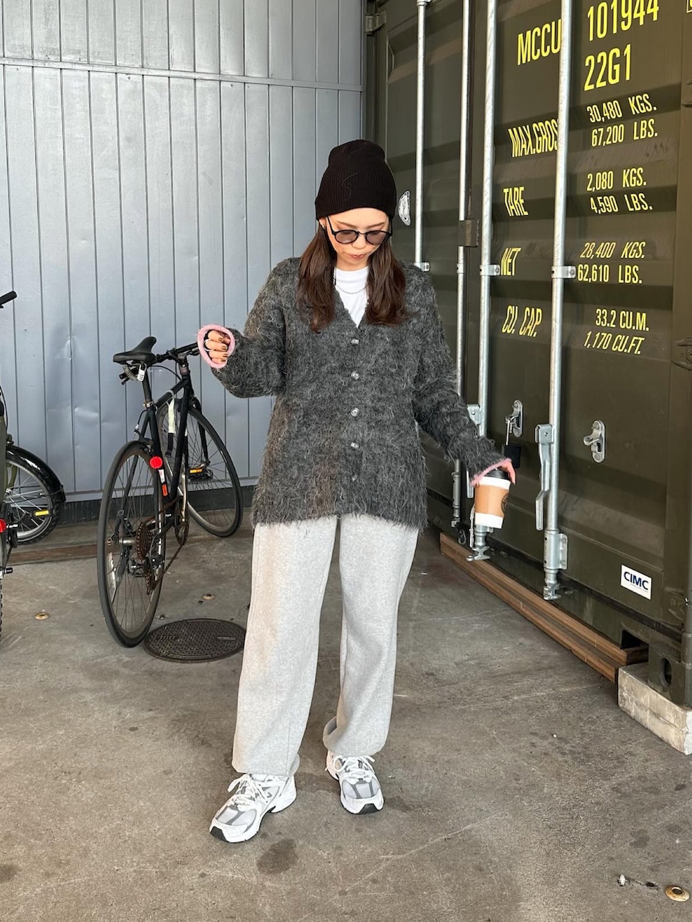 ブラック系のカーディガン/ボレロ、ホワイト系のスニーカー、ブラック系のニットキャップ/ビーニーを着用したレディースの秋コーディネートの3枚目の写真