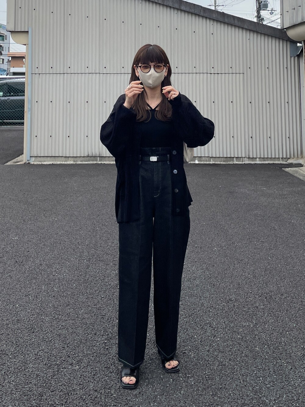 ブラック系のカーディガン/ボレロ、ブラック系のデニムパンツ、ホワイト系のハンドバッグを着用したレディースの春コーディネートの3枚目の写真