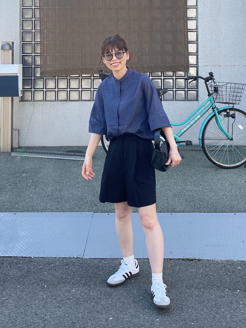 ブルー系のシャツ/ブラウス、ブラック系のその他パンツ、ホワイト系のスニーカーを着用したレディースの春コーディネートの3枚目の写真