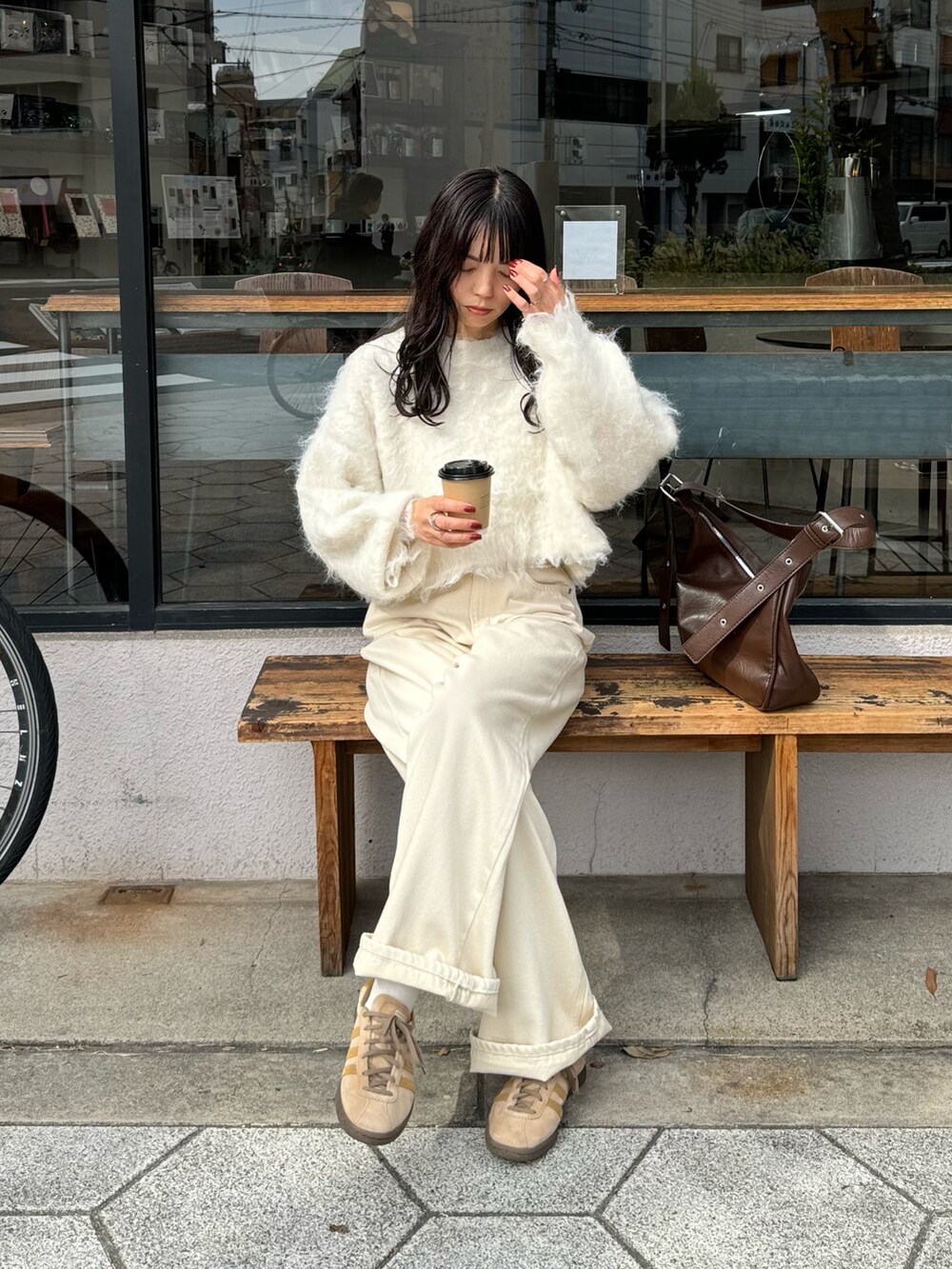ホワイト系のニット/セーター、ホワイト系のデニムパンツ、ブラウン系のショルダーバッグを着用したレディースの冬コーディネートの2枚目の写真