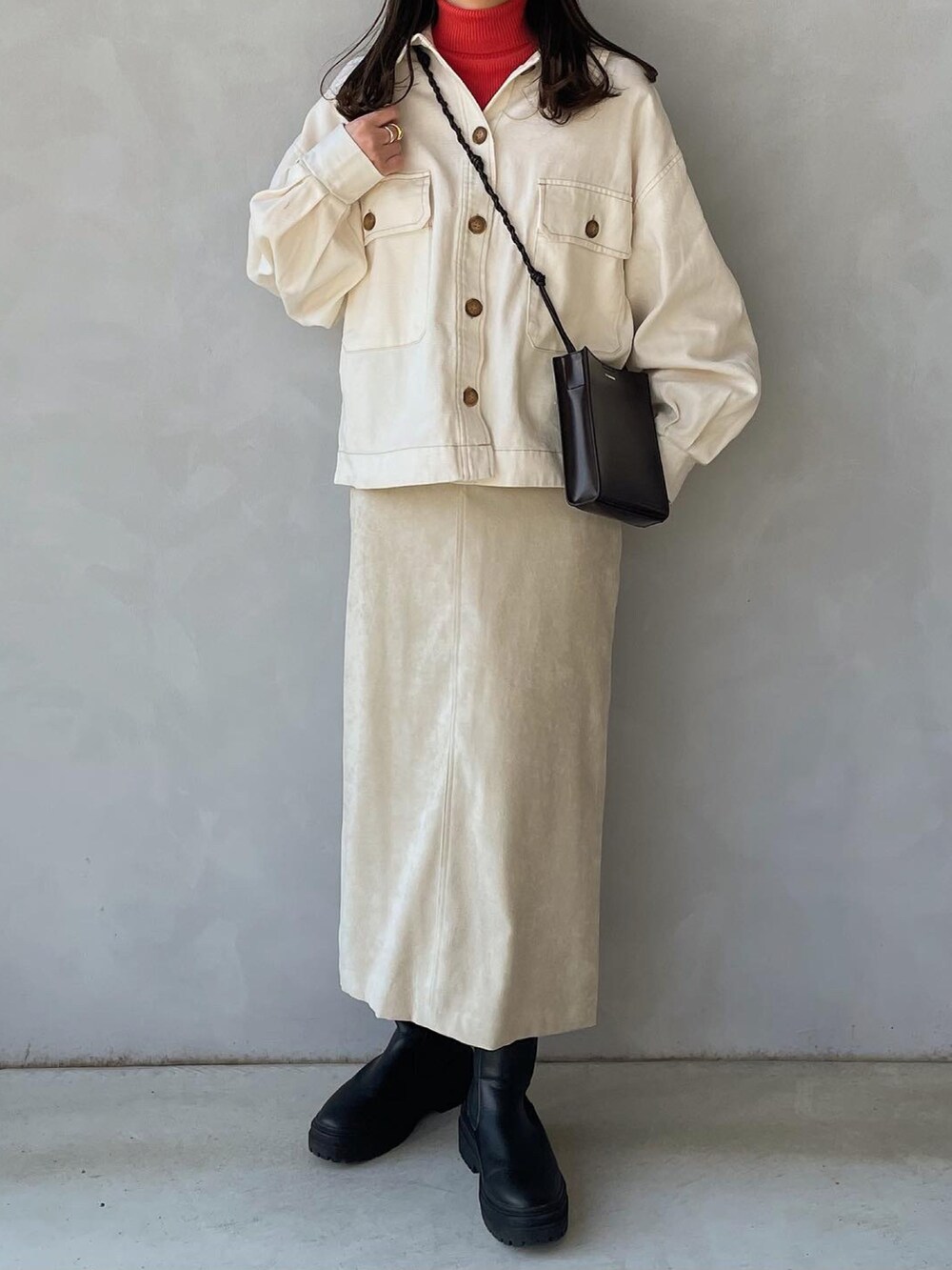 ホワイト系のブルゾン、オレンジ系のTシャツ/カットソー、ホワイト系のスカートを着用したレディースの春コーディネートの2枚目の写真