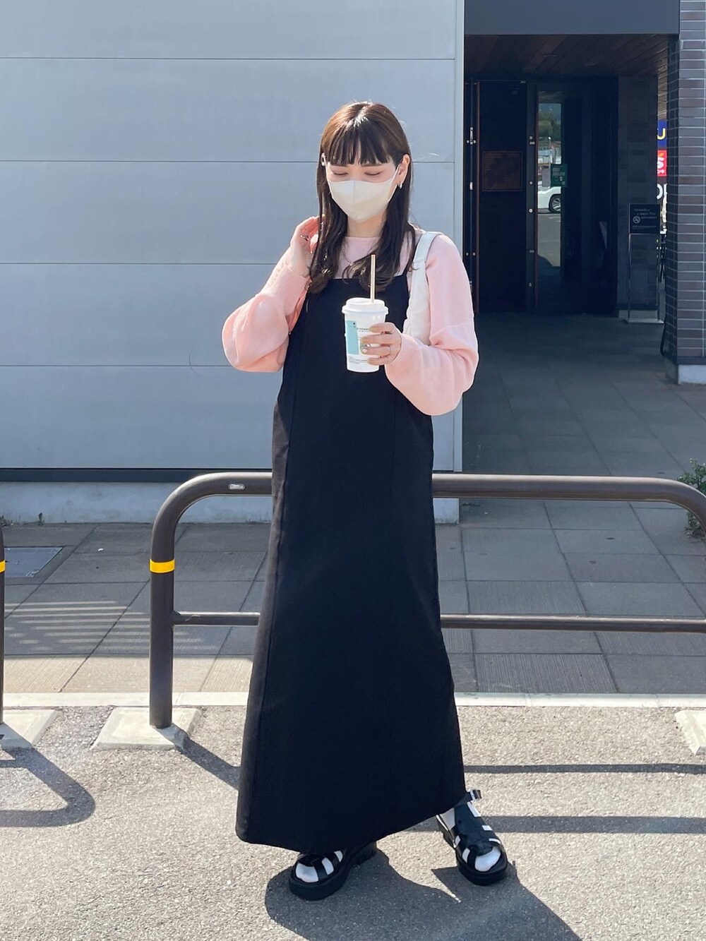 ブラック系のワンピース、ホワイト系のハンドバッグを着用したレディースの春コーディネートの5枚目の写真