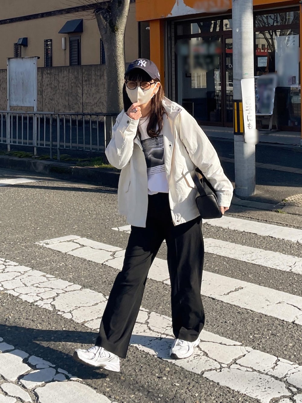 ホワイト系のマウンテンパーカー、ブルー系のキャップを着用したレディースの春コーディネートの3枚目の写真