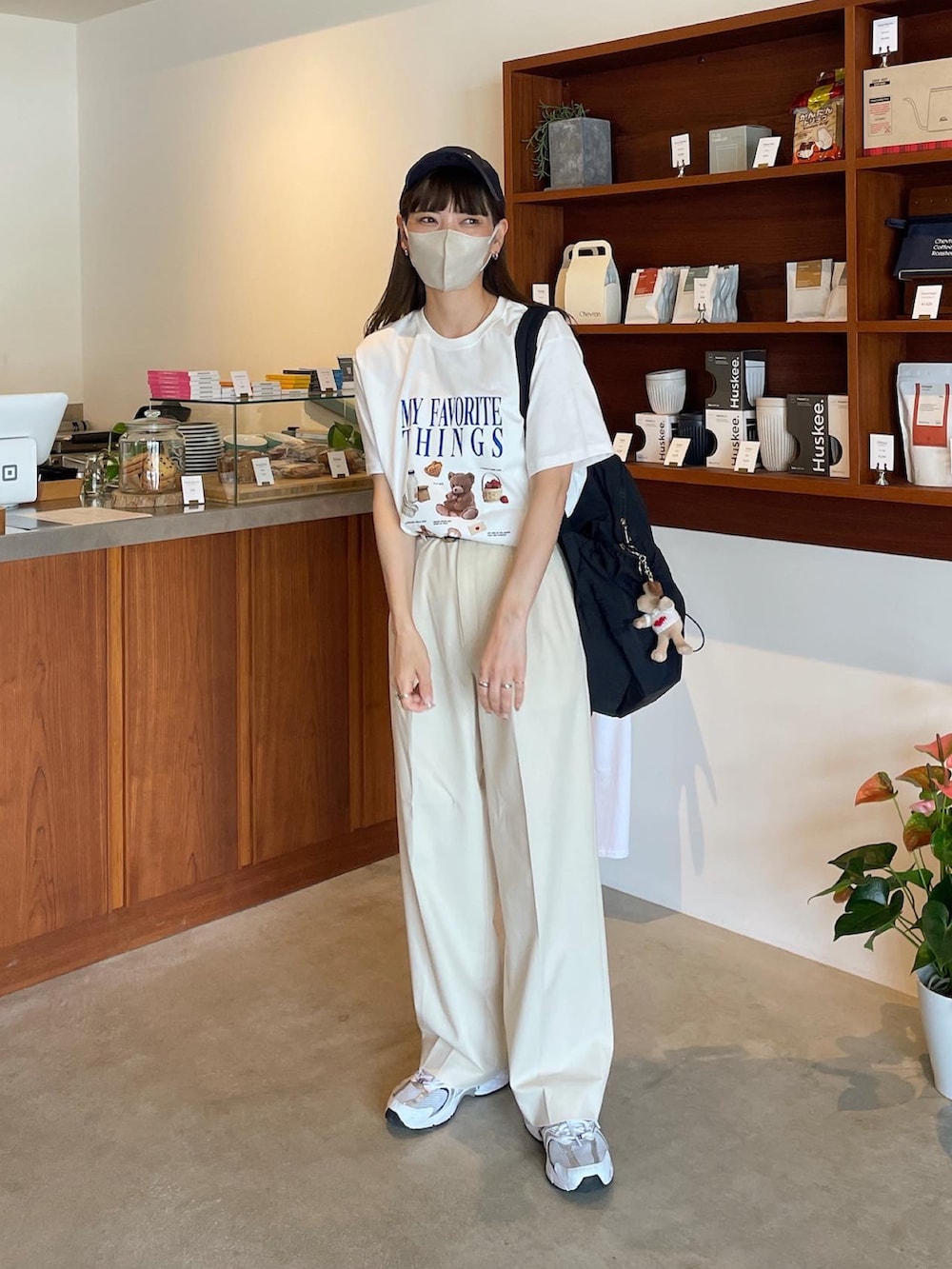 ホワイト系のTシャツ/カットソー、ブラック系のバックパック/リュック、ブルー系のキャップを着用したレディースの夏コーディネートの3枚目の写真