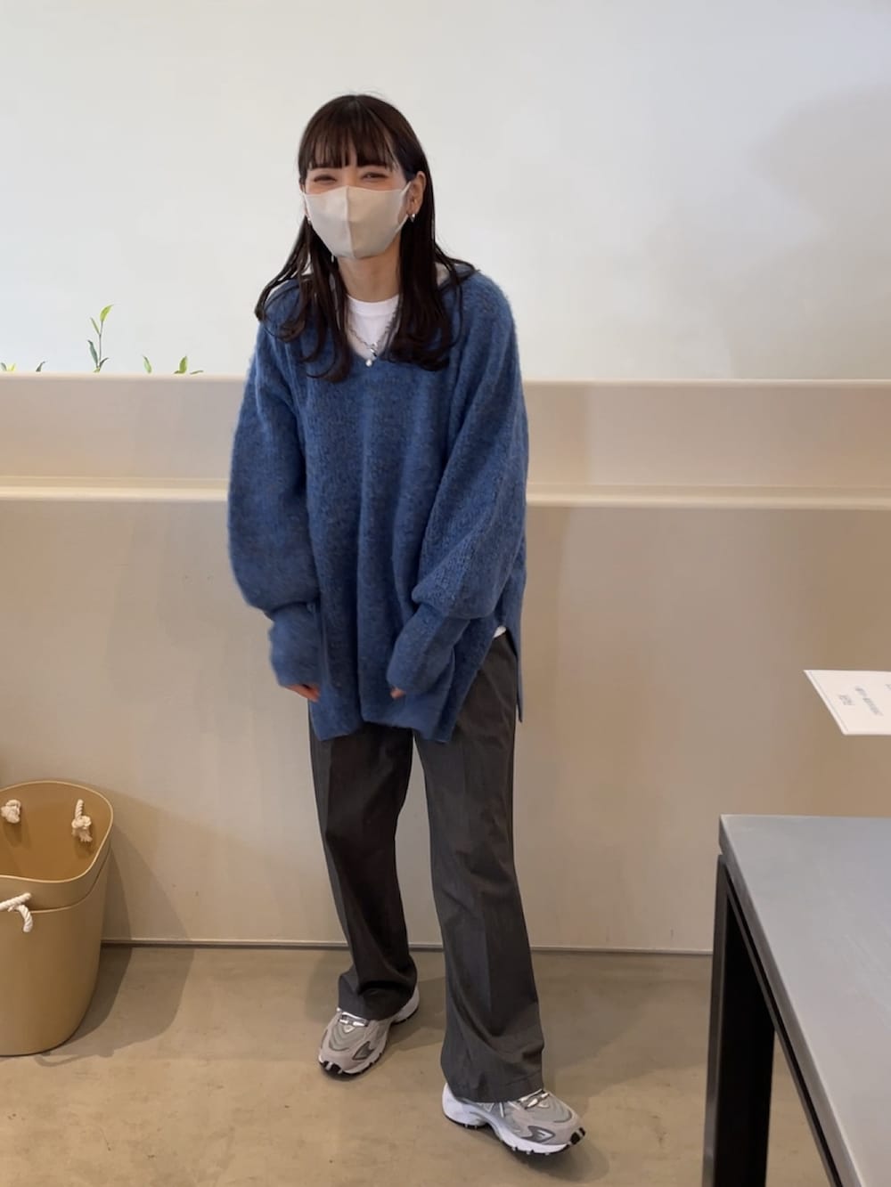 ブルー系のニット/セーター、ベージュ系のスニーカー、ホワイト系のマフラーを着用したレディースの冬コーディネートの4枚目の写真