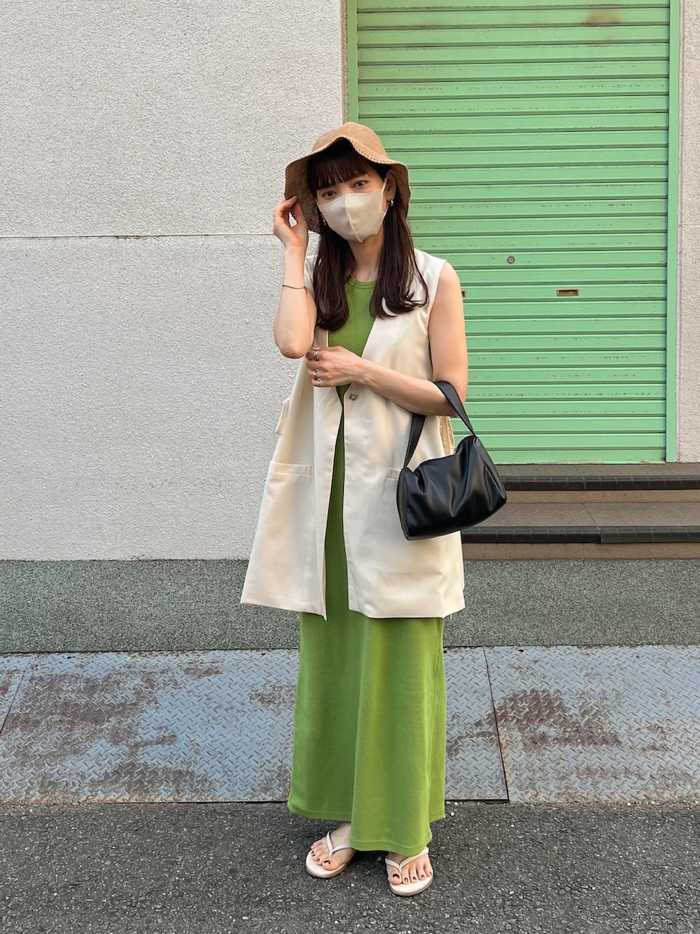 ホワイト系のベスト、グリーン系のワンピース、ベージュ系のハットを着用したレディースの夏コーディネートの3枚目の写真