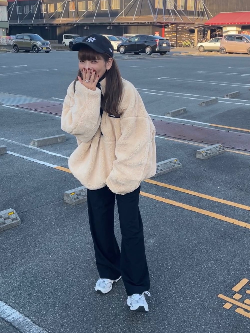 ブラック系のブルゾン、ブルー系のキャップを着用したレディースの秋コーディネートの4枚目の写真