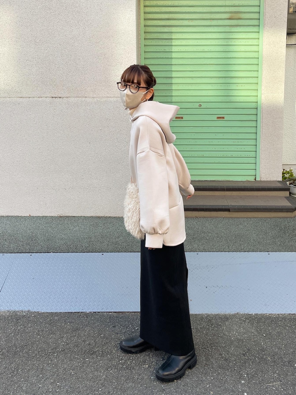 ベージュ系のパーカー、ブラック系のスカート、ホワイト系のショルダーバッグを着用したレディースの秋コーディネートの2枚目の写真