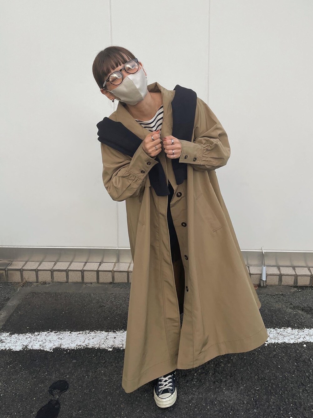 ベージュ系のトレンチコートを着用したレディースの秋コーディネートの4枚目の写真