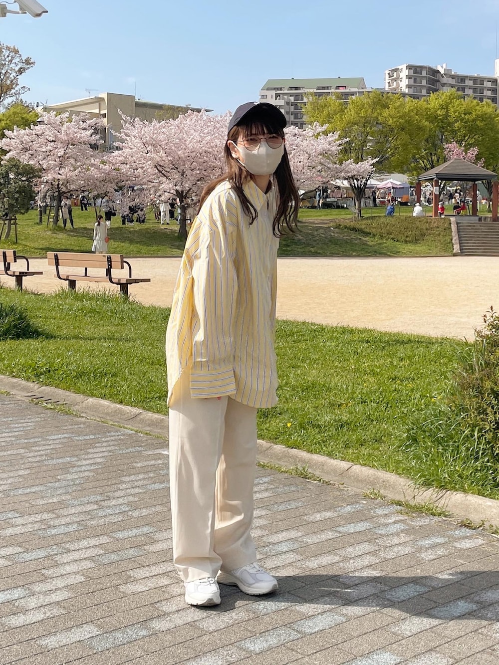 イエロー系のシャツ/ブラウス、ホワイト系のトートバッグ、ホワイト系のスニーカーを着用したレディースの春コーディネートの3枚目の写真