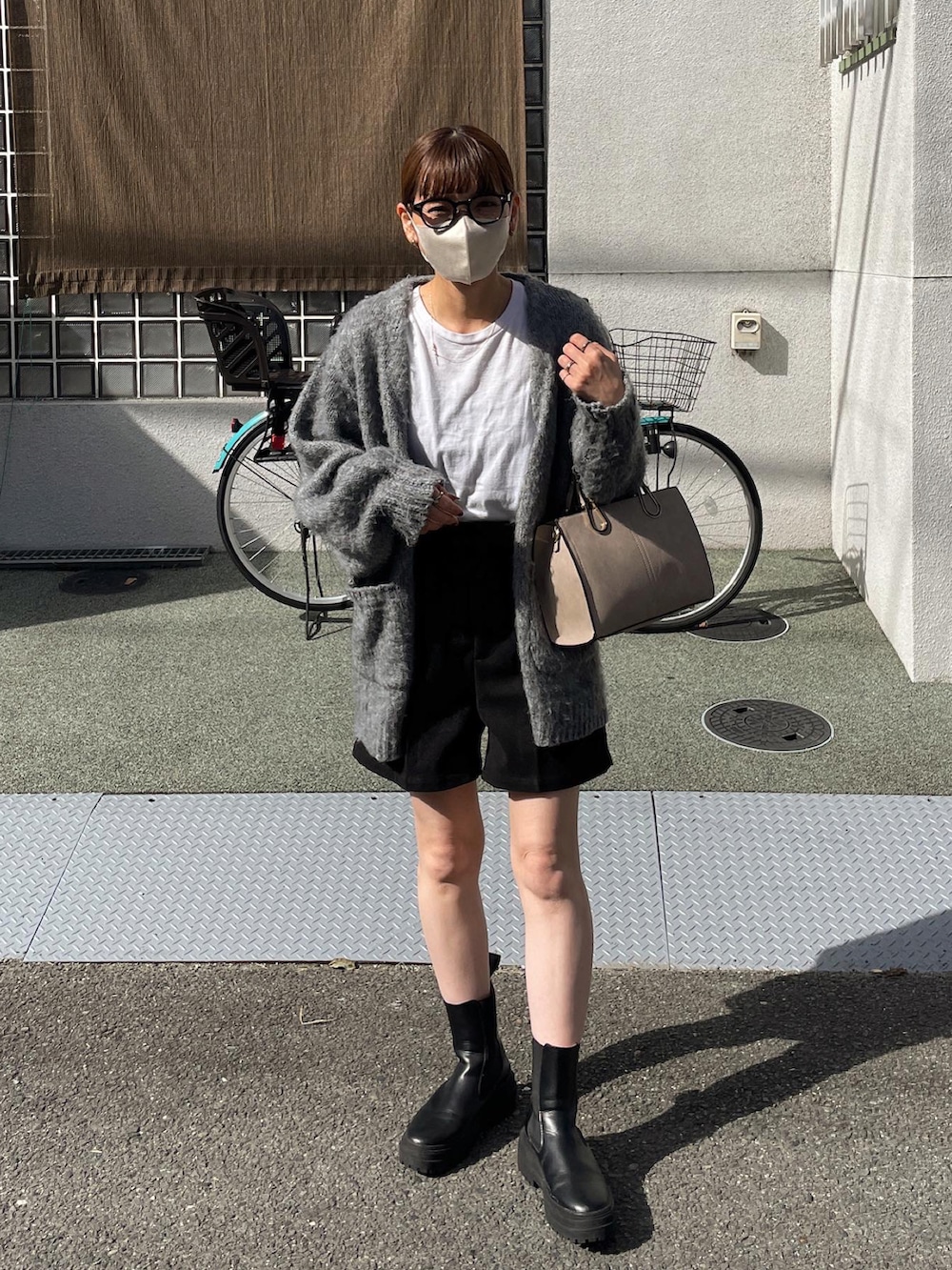 ブラック系のその他パンツ、グレー系のカーディガン/ボレロ、ベージュ系のショルダーバッグを着用したレディースの秋コーディネートの2枚目の写真