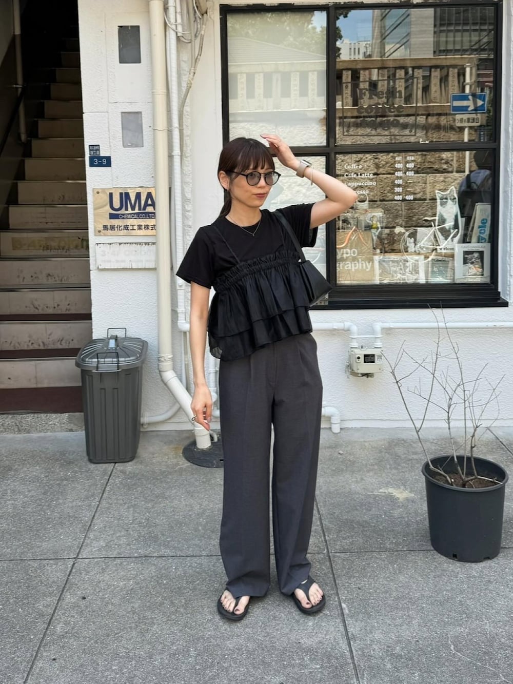 ブラック系のキャミソール、グレー系のスラックス、ブラック系のショルダーバッグを着用したレディースの夏コーディネートの2枚目の写真