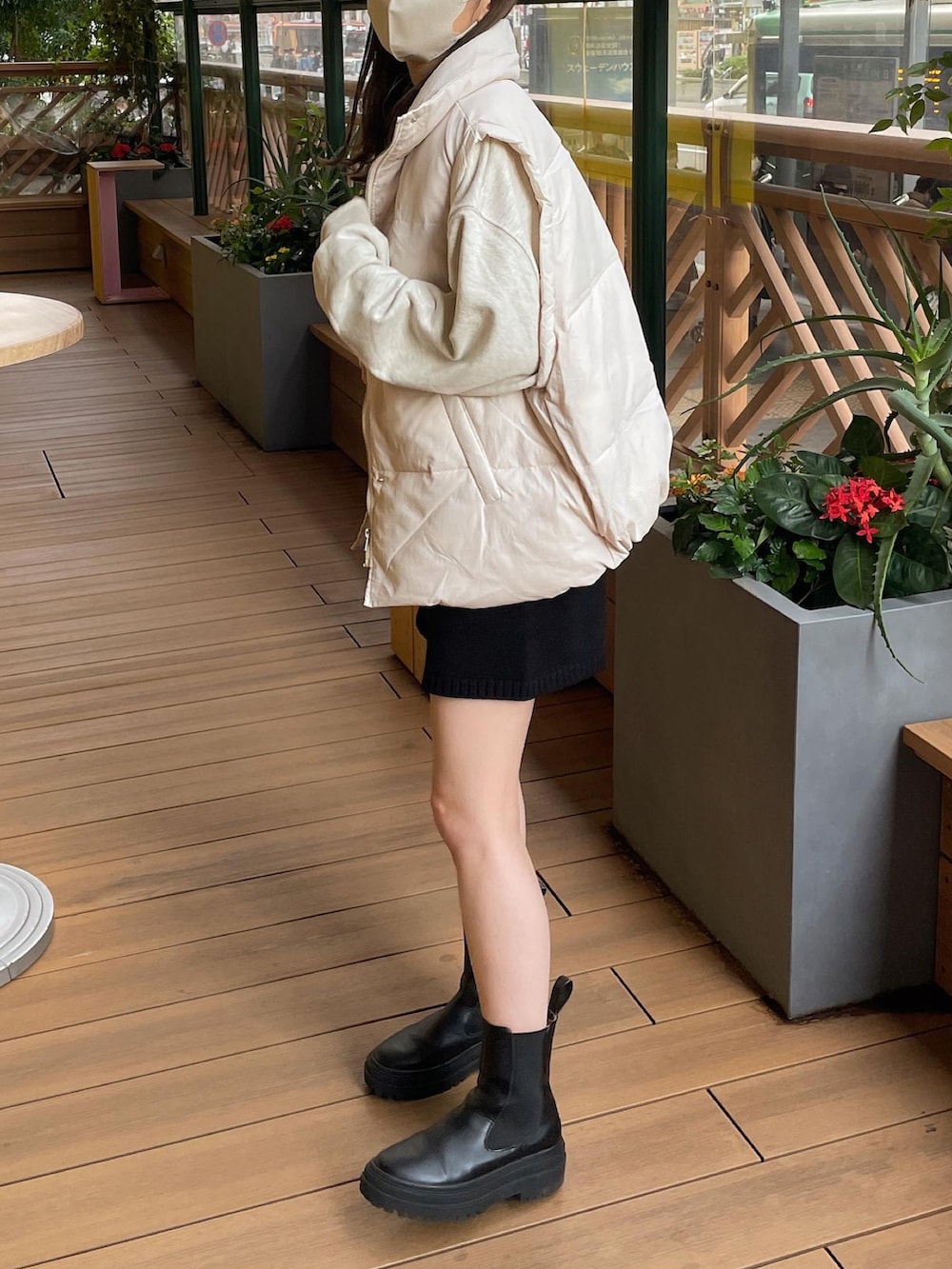 ホワイト系のダウンベスト、ベージュ系のスウェット、ブラック系のその他パンツを着用したレディースの秋コーディネートの4枚目の写真