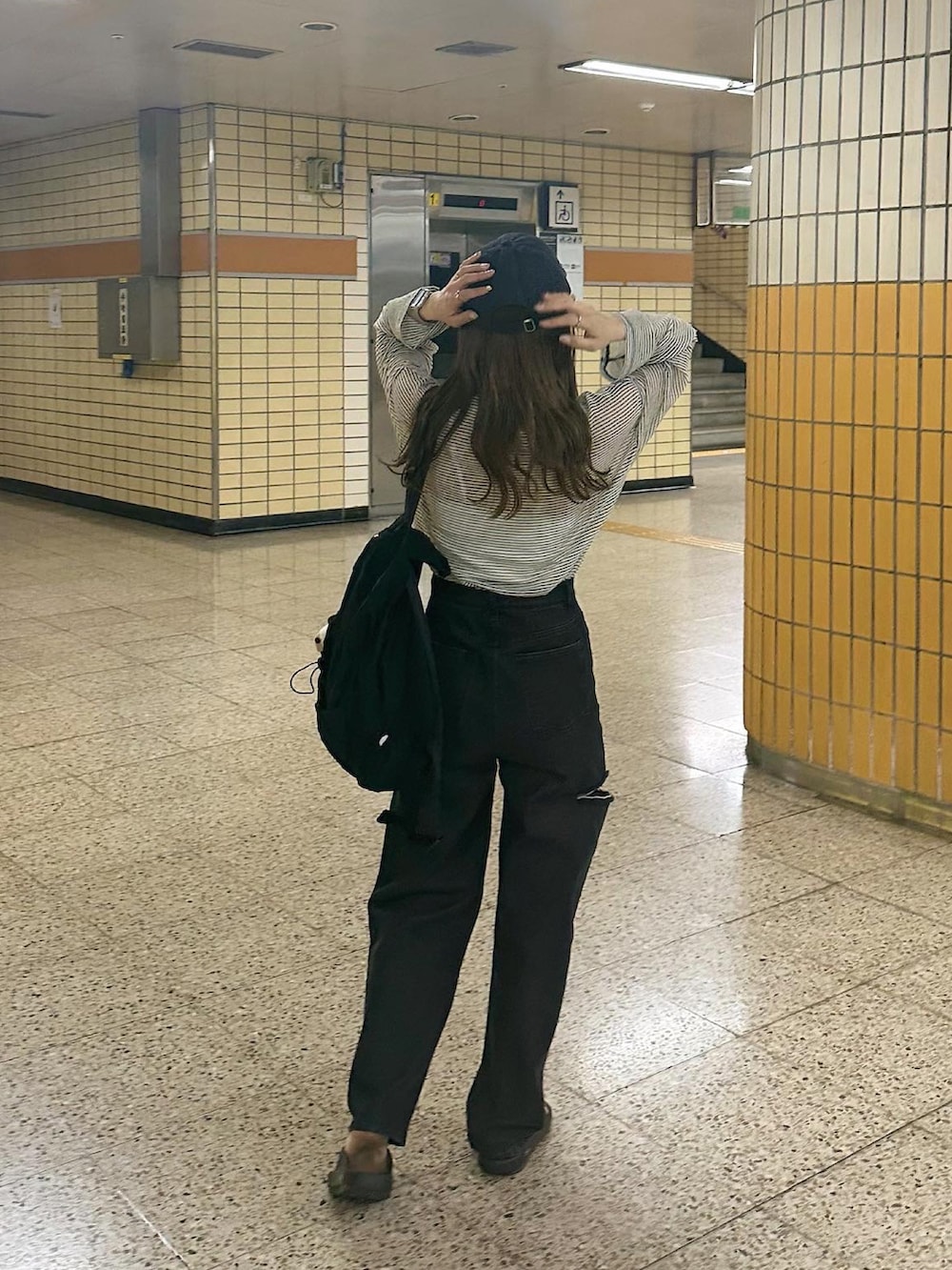 ブラック系のデニムパンツ、ホワイト系のTシャツ/カットソー、ブルー系のキャップを着用したレディースの春コーディネートの3枚目の写真