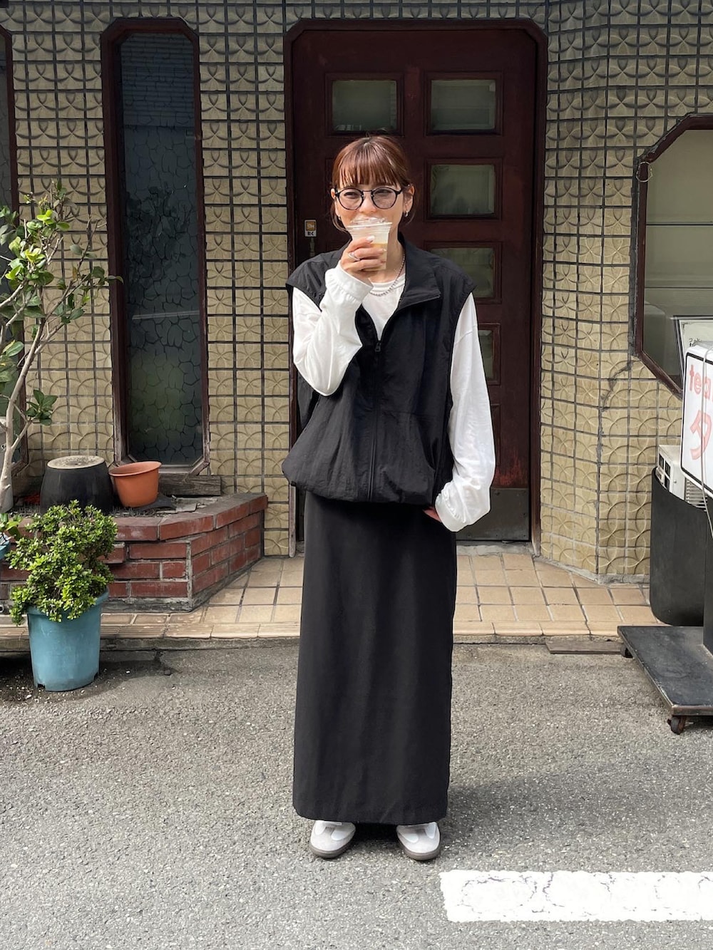 ブラック系のベスト、ホワイト系のTシャツ/カットソー、ブラック系のスカートを着用したレディースの秋コーディネートの3枚目の写真