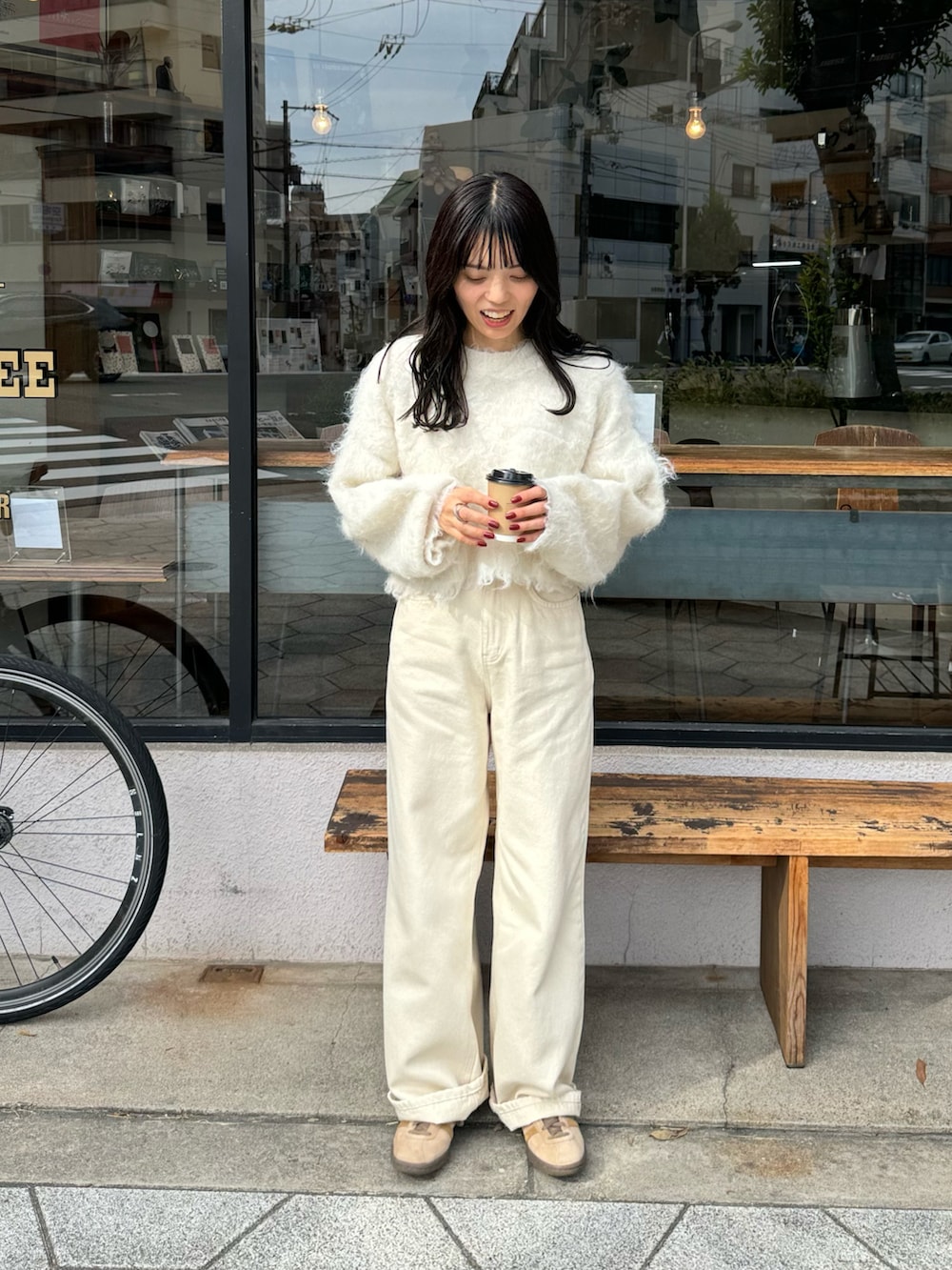 ホワイト系のニット/セーター、ホワイト系のデニムパンツ、ブラウン系のショルダーバッグを着用したレディースの冬コーディネートの4枚目の写真