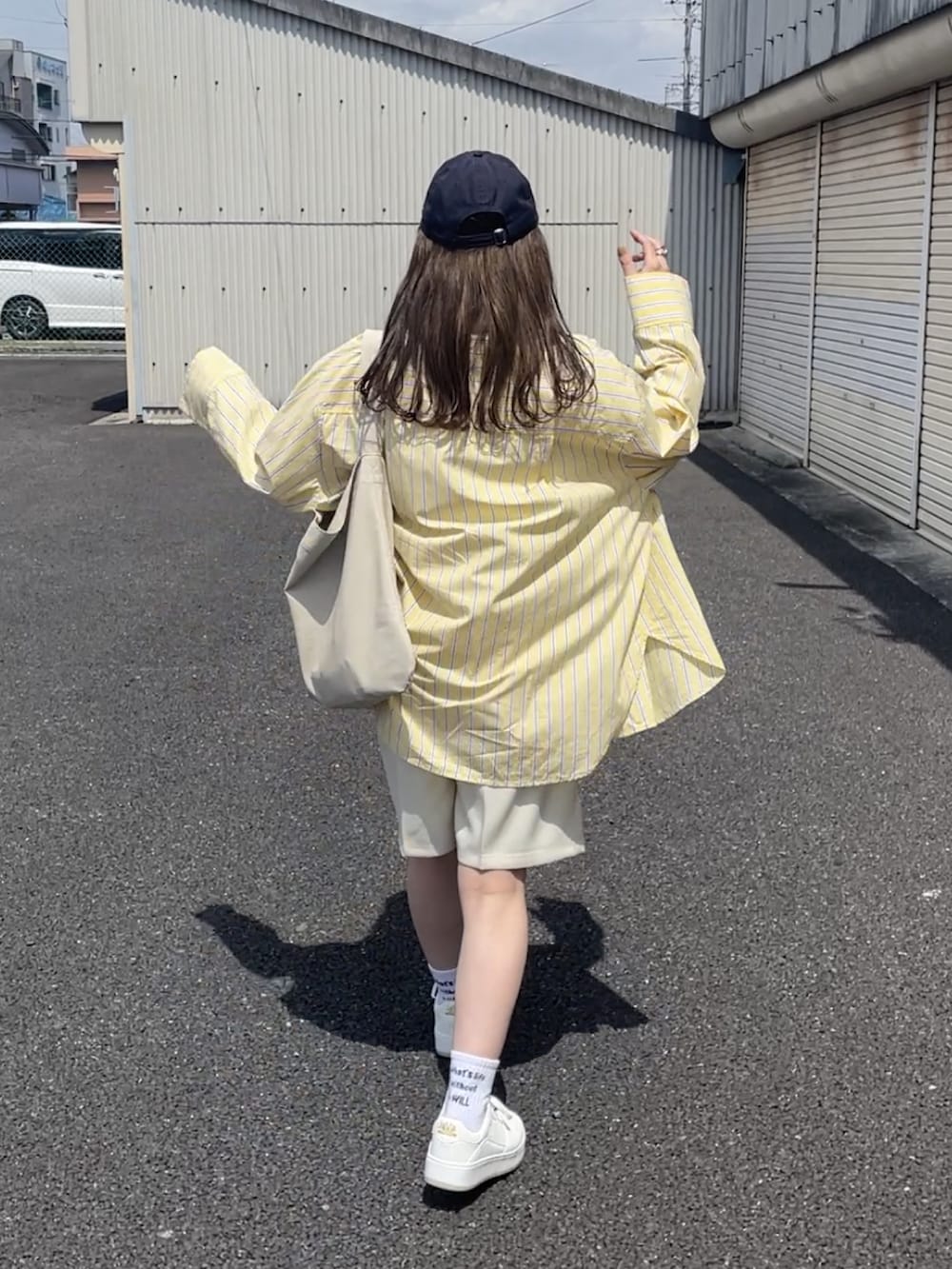 イエロー系のシャツ/ブラウス、ホワイト系のその他パンツ、ホワイト系のトートバッグを着用したレディースの春コーディネートの3枚目の写真