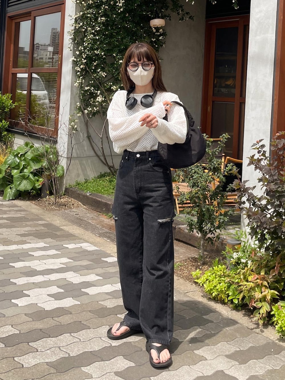 ホワイト系のニット/セーター、ブラック系のデニムパンツ、ブラック系のハンドバッグを着用したレディースの春コーディネートの4枚目の写真