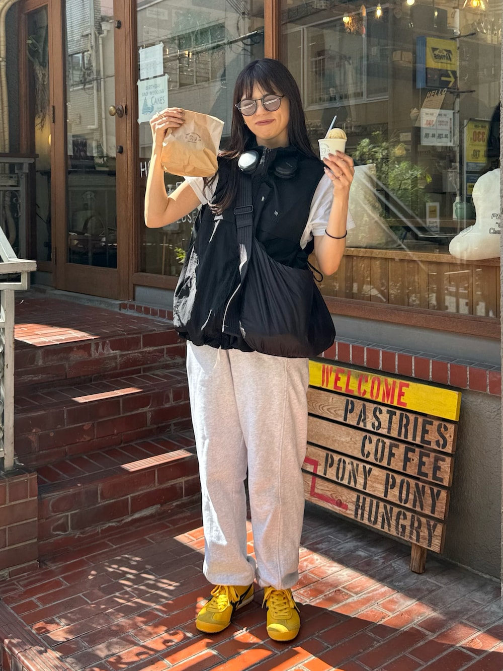 ブラック系のベスト、グレー系のスウェットパンツ、ブラック系のショルダーバッグを着用したレディースの秋コーディネートの3枚目の写真