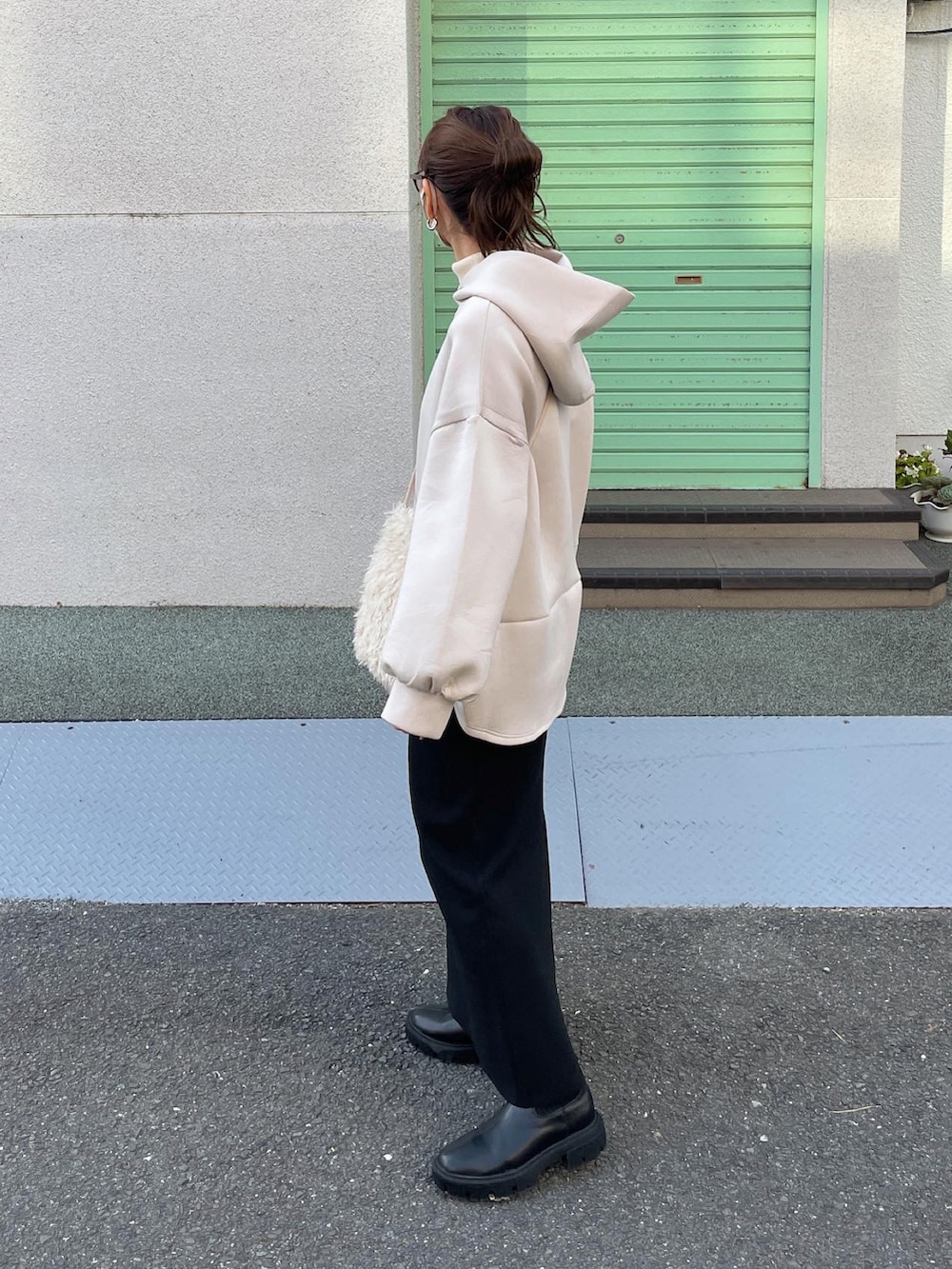 ベージュ系のパーカー、ブラック系のスカート、ホワイト系のショルダーバッグを着用したレディースの秋コーディネートの5枚目の写真