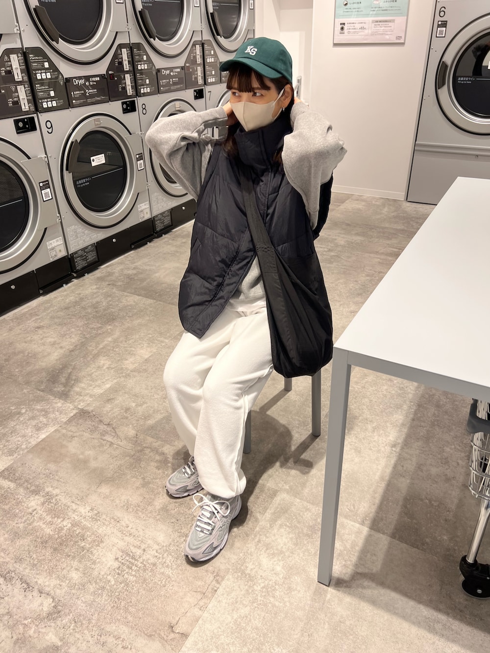 ブラック系のダウンベスト、グレー系のニット/セーター、ホワイト系のその他パンツを着用したレディースの冬コーディネートの5枚目の写真