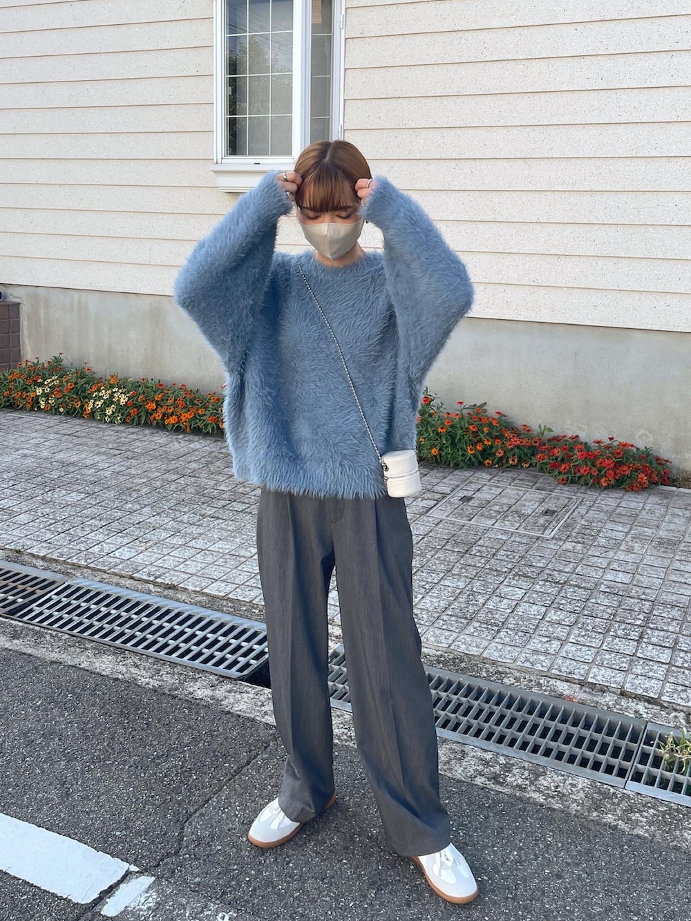 ブルー系のニット/セーター、ホワイト系のショルダーバッグを着用したレディースの秋コーディネートの3枚目の写真