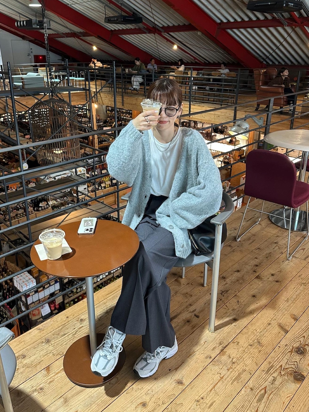 グレー系のカーディガン/ボレロ、グレー系のスラックス、ホワイト系のスニーカーを着用したレディースの秋コーディネートの2枚目の写真