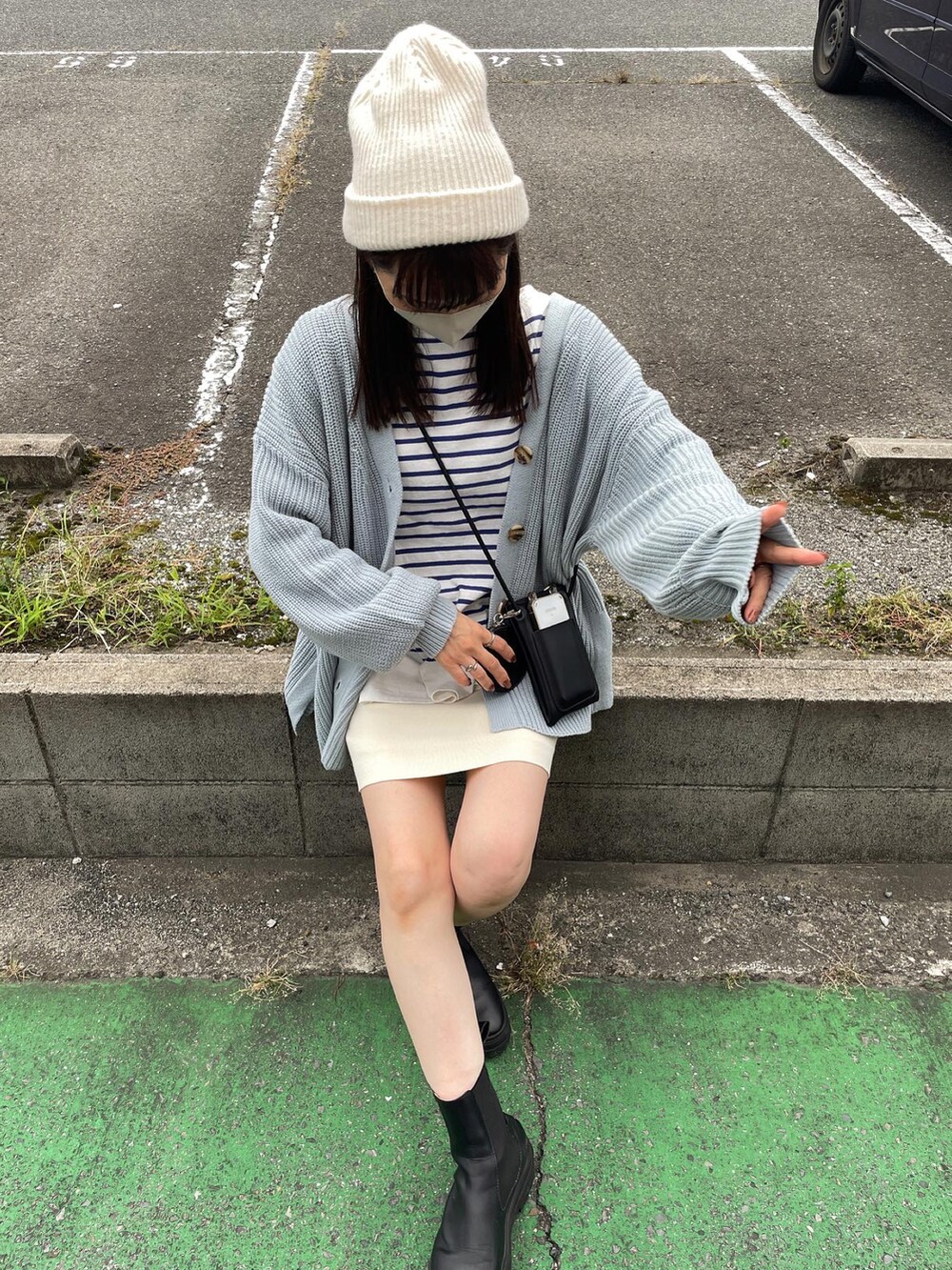 ブルー系のカーディガン/ボレロ、ホワイト系のスカート、ブラック系のショルダーバッグを着用したレディースの秋コーディネートの4枚目の写真