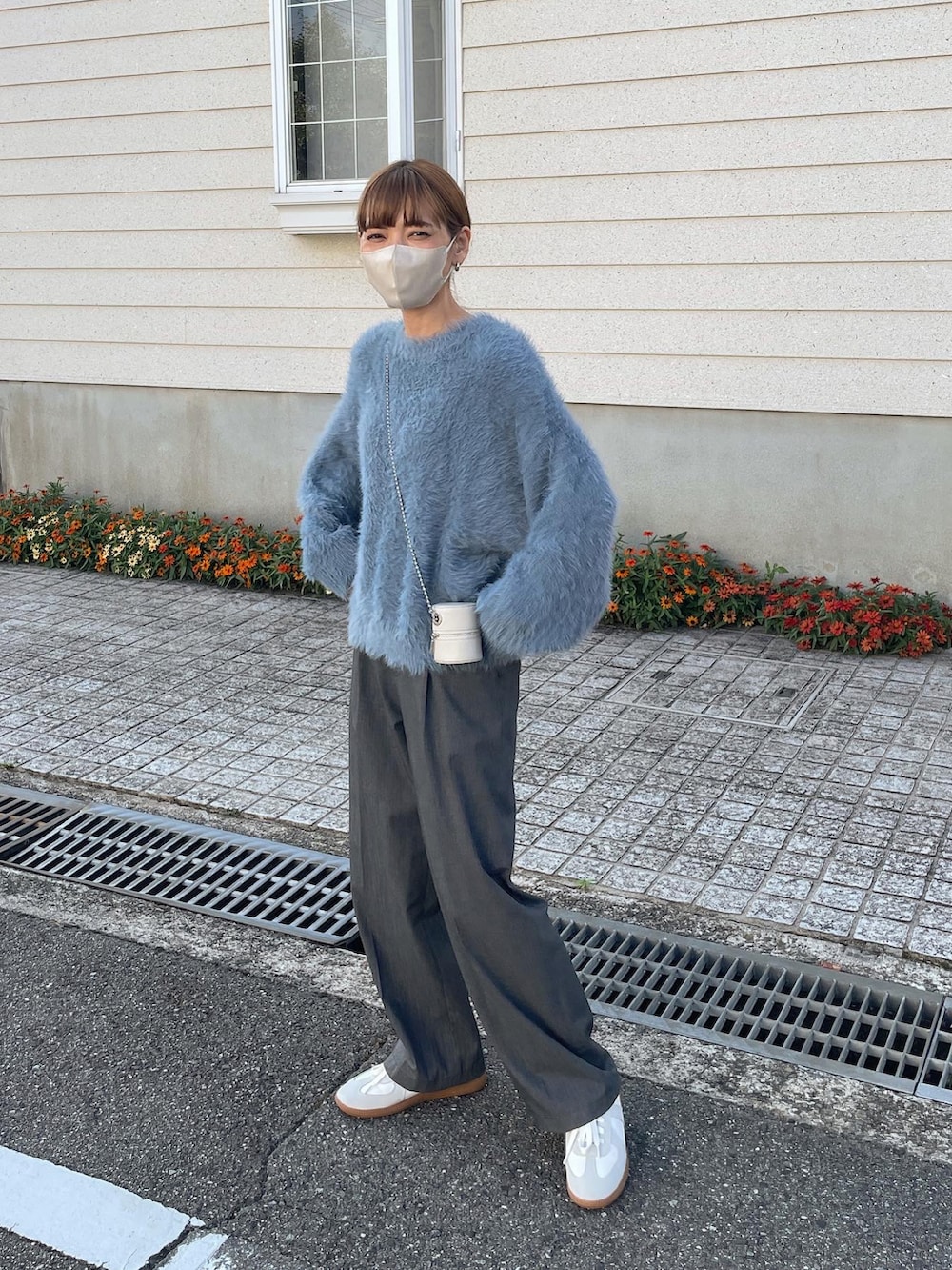 ブルー系のニット/セーター、ホワイト系のショルダーバッグを着用したレディースの秋コーディネートの2枚目の写真