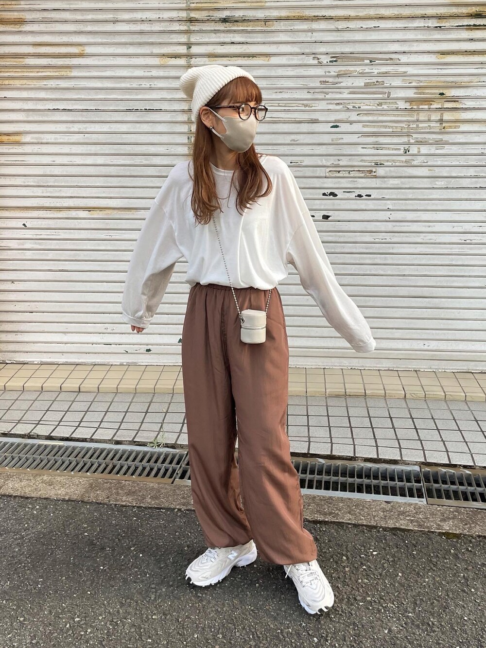 ブラウン系のその他パンツ、ホワイト系のショルダーバッグ、ベージュ系のスニーカーを着用したレディースの秋コーディネートの5枚目の写真