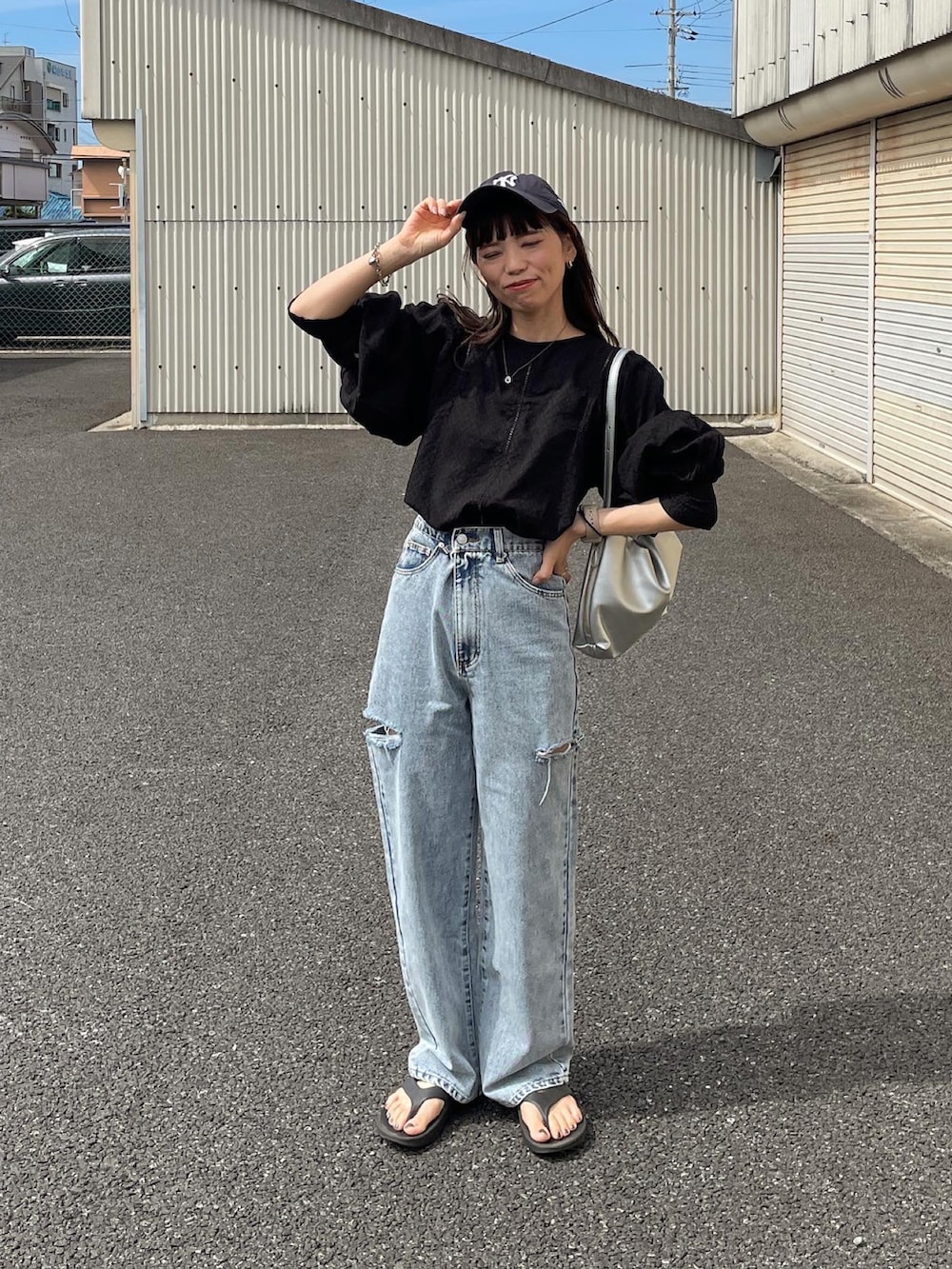 ブラック系のシャツ/ブラウス、ブルー系のデニムパンツ、シルバー系のショルダーバッグを着用したレディースの夏コーディネートの4枚目の写真