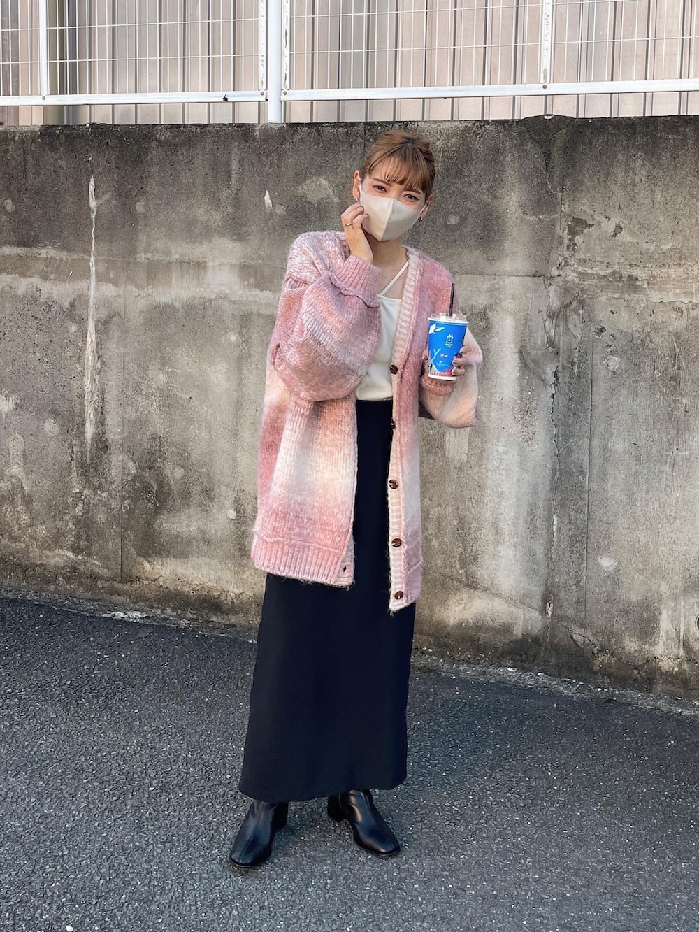 ピンク系のカーディガン/ボレロ、ブラック系のスカート、ホワイト系のキャミソールを着用したレディースの秋コーディネートの2枚目の写真