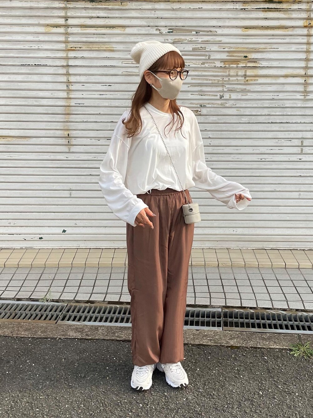 ブラウン系のその他パンツ、ホワイト系のショルダーバッグ、ベージュ系のスニーカーを着用したレディースの秋コーディネートの4枚目の写真