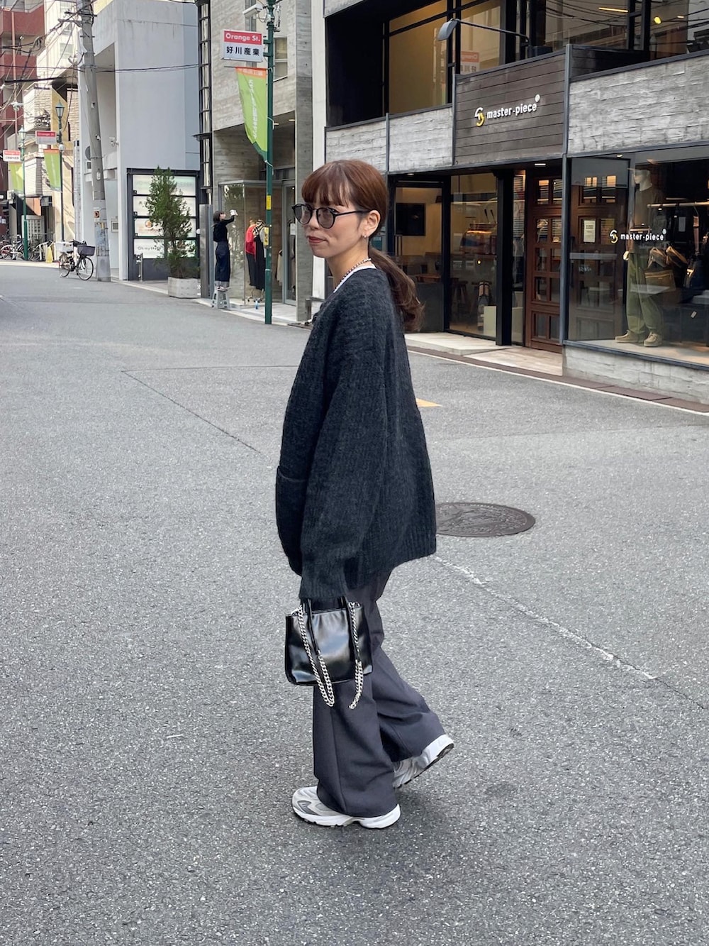 グレー系のカーディガン/ボレロ、グレー系のスラックス、ブラック系のショルダーバッグを着用したレディースの秋コーディネートの4枚目の写真