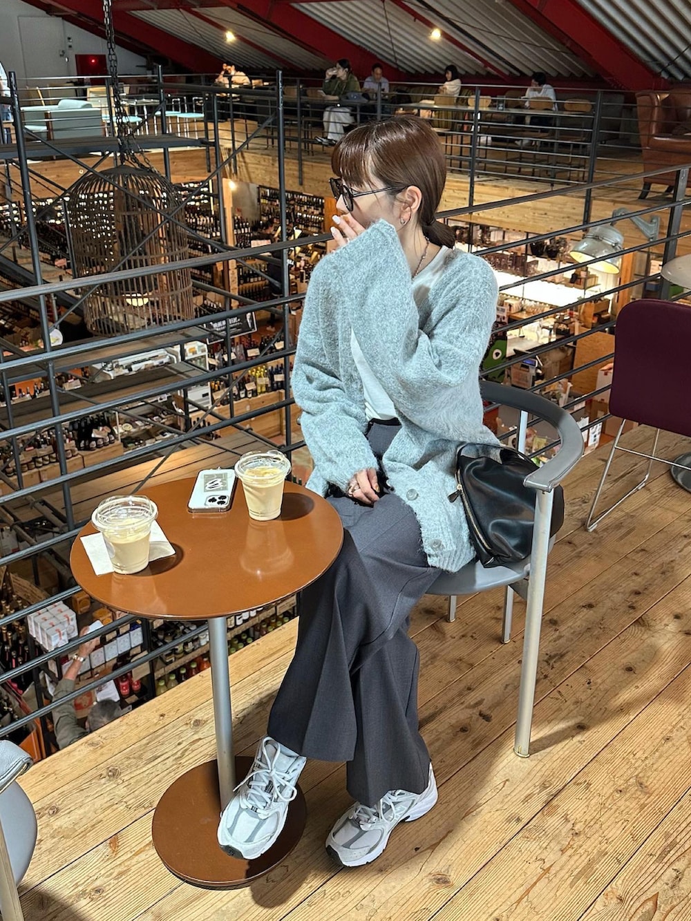 グレー系のカーディガン/ボレロ、グレー系のスラックス、ホワイト系のスニーカーを着用したレディースの秋コーディネートの4枚目の写真