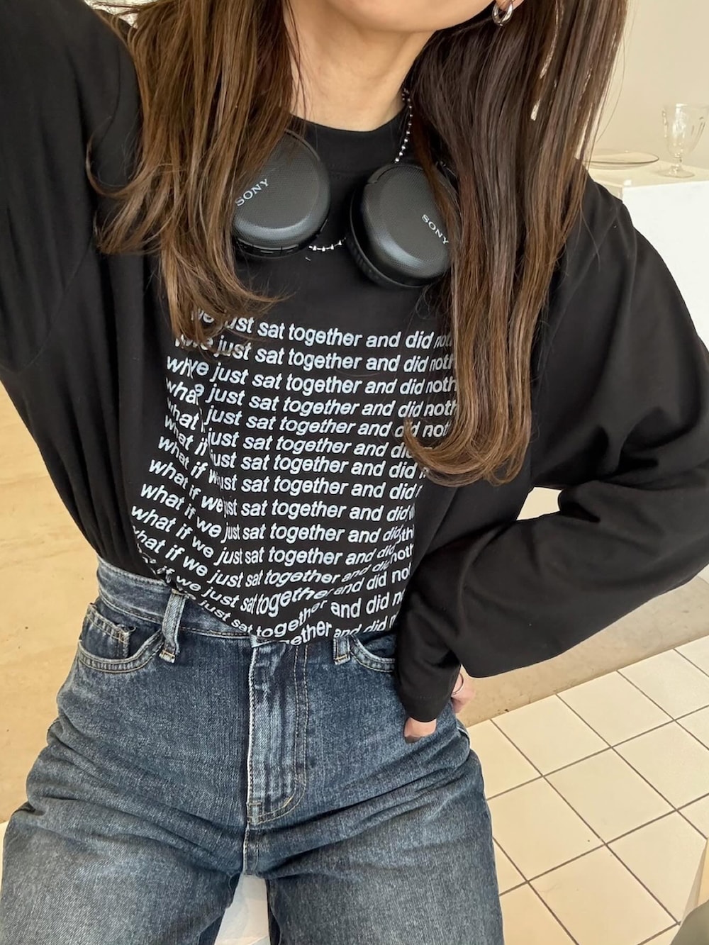 ブラック系のTシャツ/カットソー、ブルー系のデニムパンツ、ブラック系のスニーカーを着用したレディースの春コーディネートの3枚目の写真