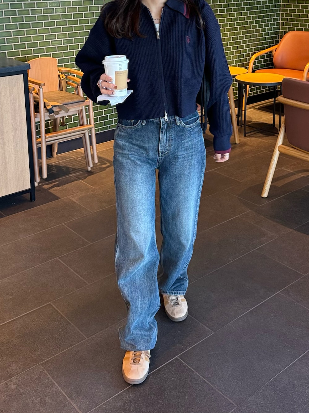 ブルー系のニット/セーター、ブルー系のデニムパンツ、ベージュ系のスニーカーを着用したレディースの秋コーディネートの3枚目の写真