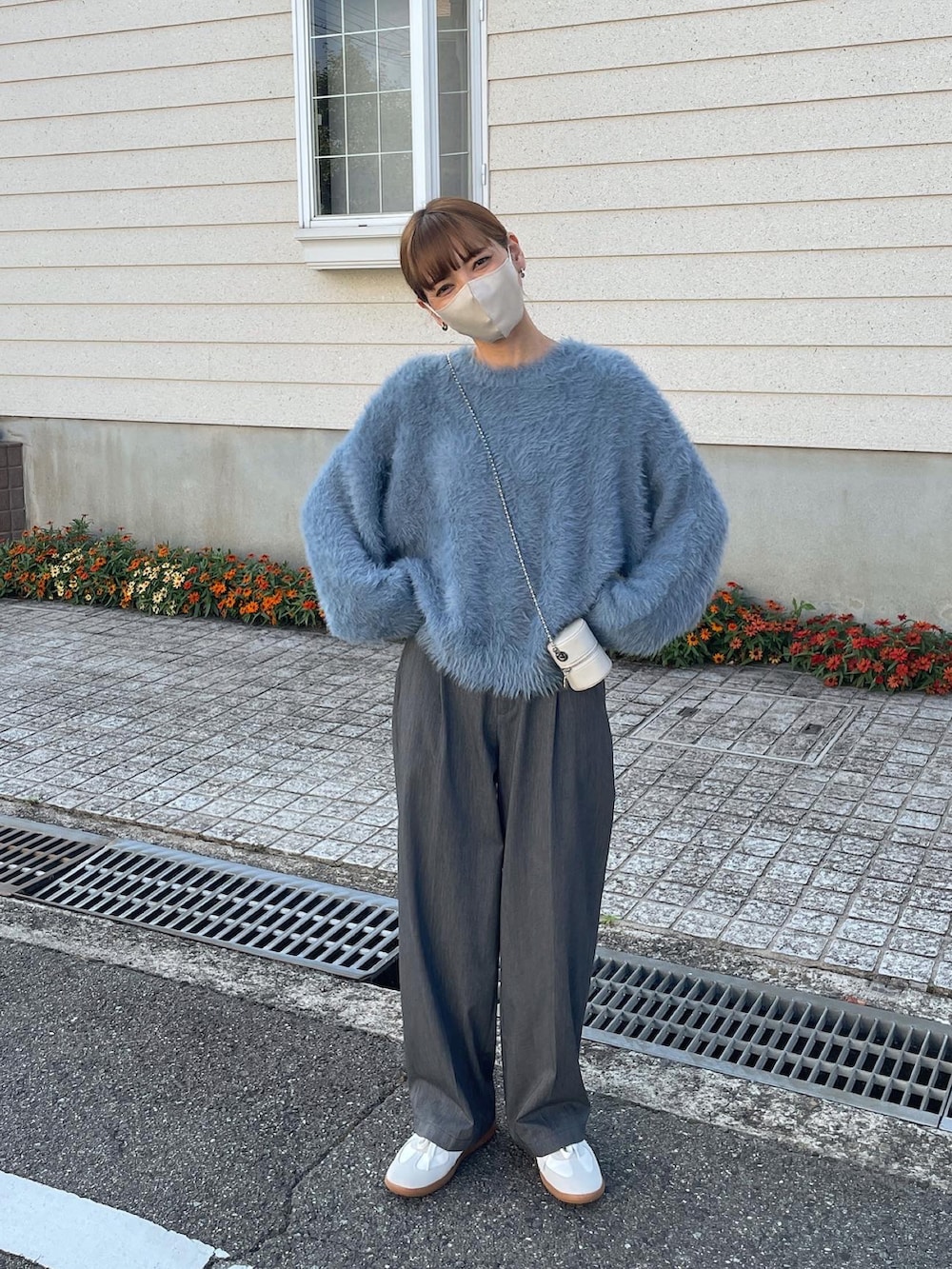 ブルー系のニット/セーター、ホワイト系のショルダーバッグを着用したレディースの秋コーディネートの4枚目の写真