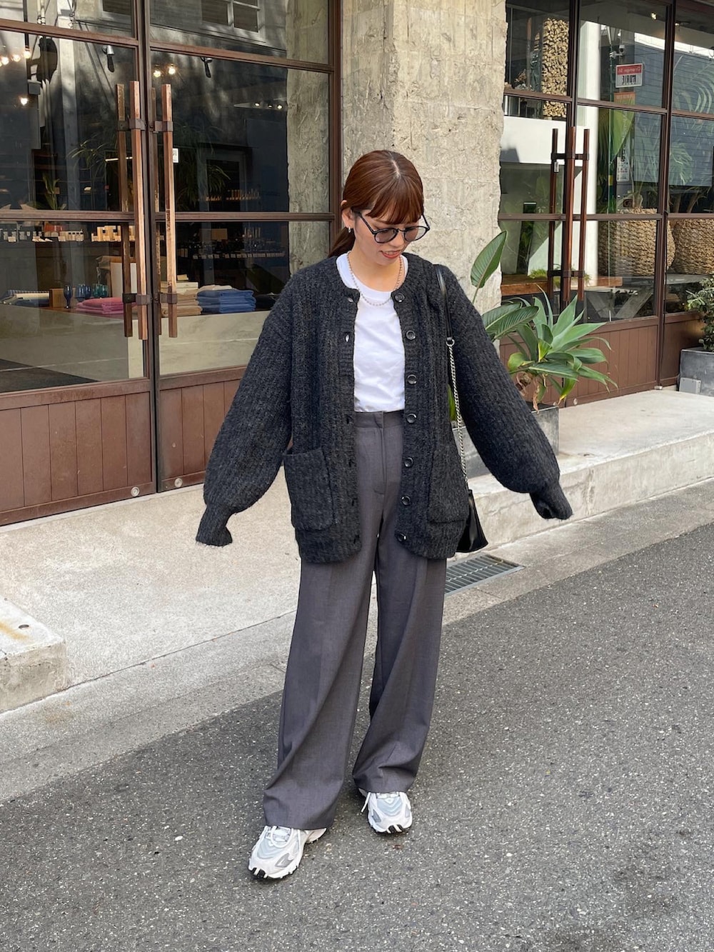 グレー系のカーディガン/ボレロ、グレー系のスラックス、ブラック系のショルダーバッグを着用したレディースの秋コーディネートの3枚目の写真