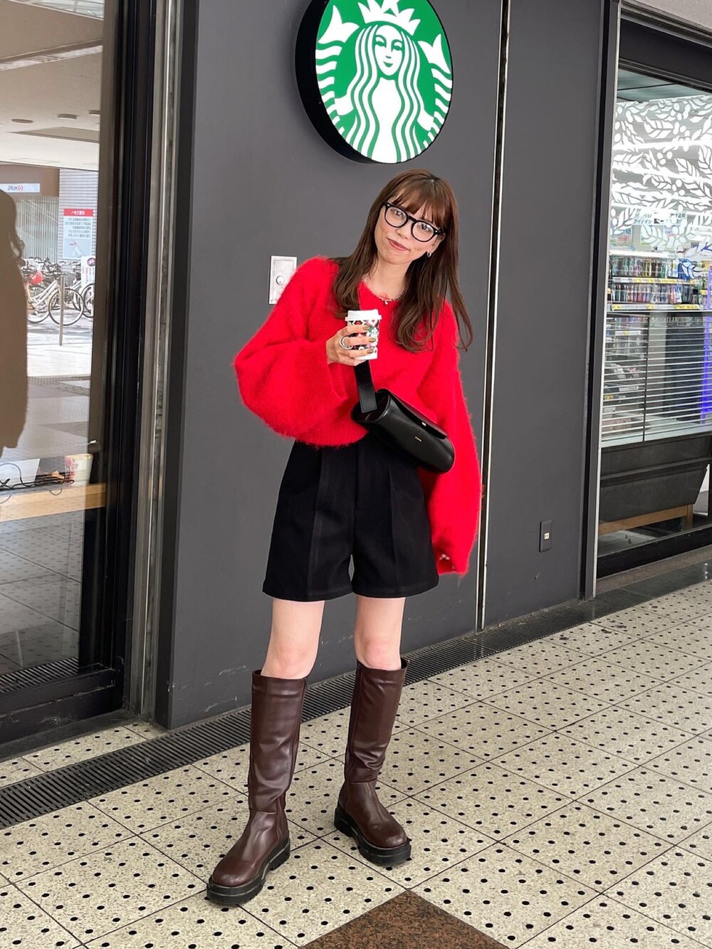 レッド系のニット/セーター、ブラック系のその他パンツ、ブラウン系のブーツを着用したレディースの秋コーディネートの5枚目の写真