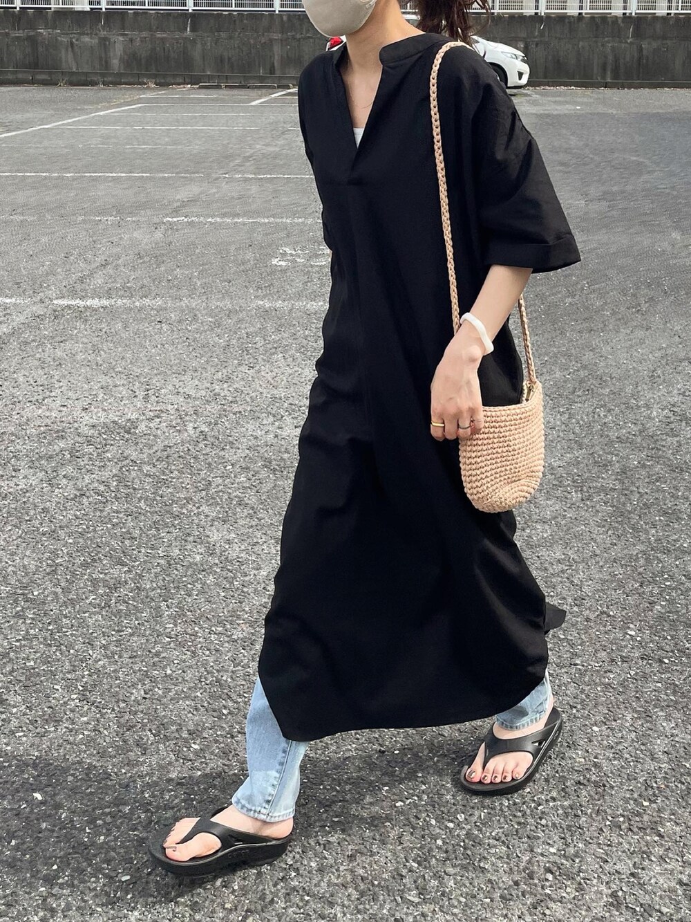 ブラック系のワンピース、ブルー系のデニムパンツ、ベージュ系のショルダーバッグを着用したレディースの夏コーディネートの3枚目の写真