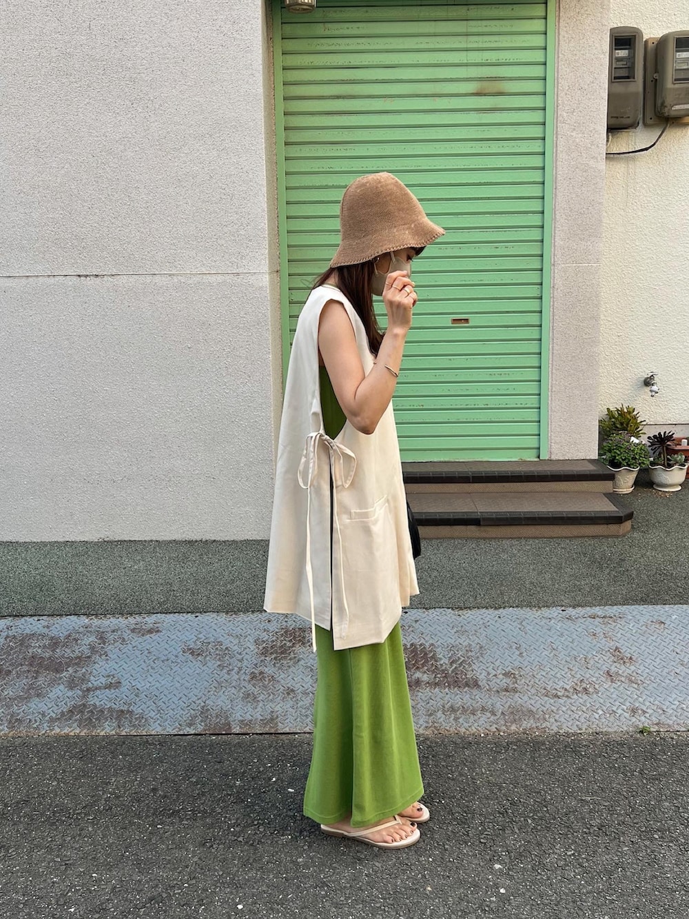 ホワイト系のベスト、グリーン系のワンピース、ベージュ系のハットを着用したレディースの夏コーディネートの4枚目の写真