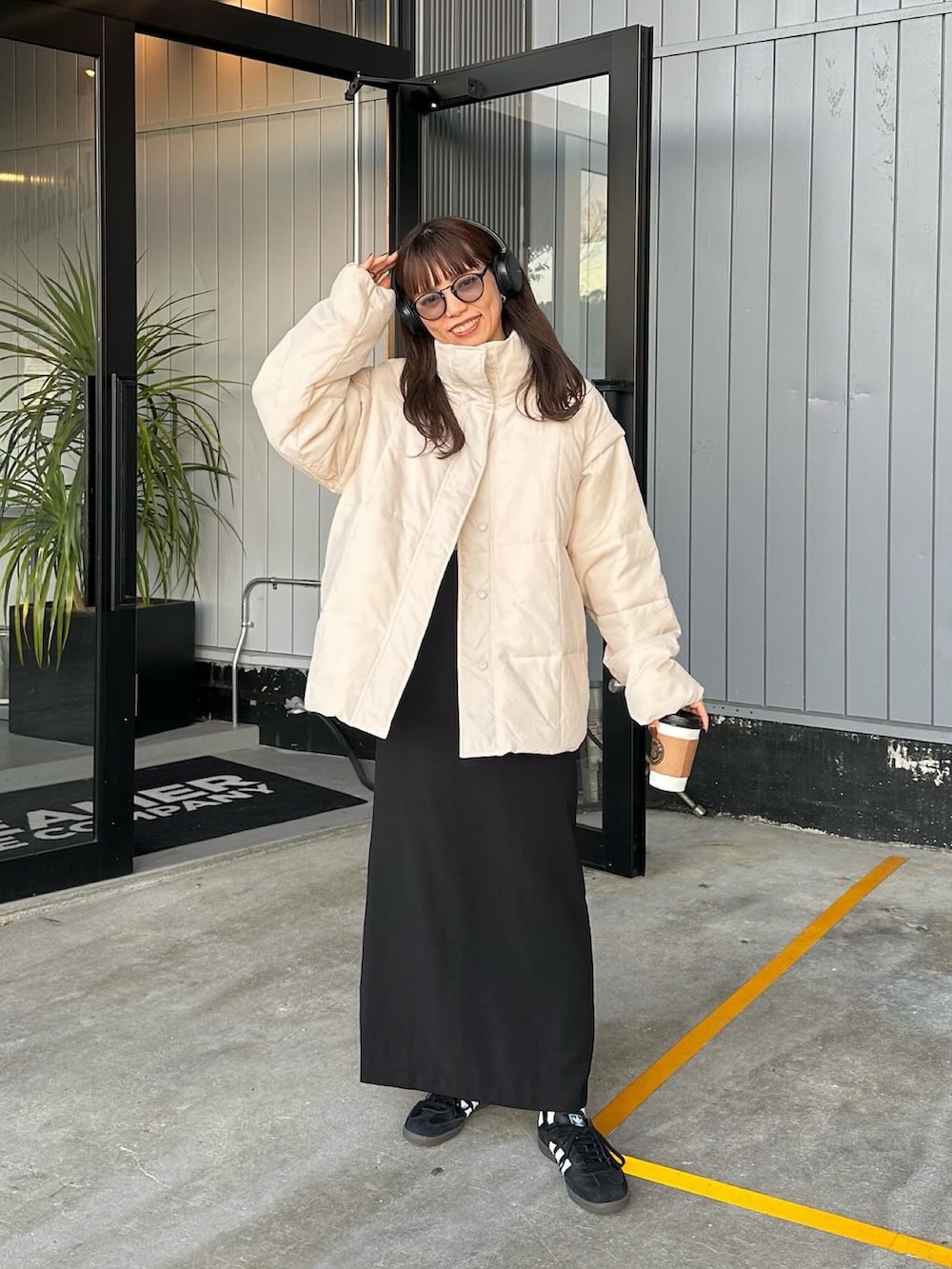 ホワイト系のダウンジャケット/コート、ブラック系のスカート、ブラック系のスニーカーを着用したレディースの冬コーディネートの5枚目の写真
