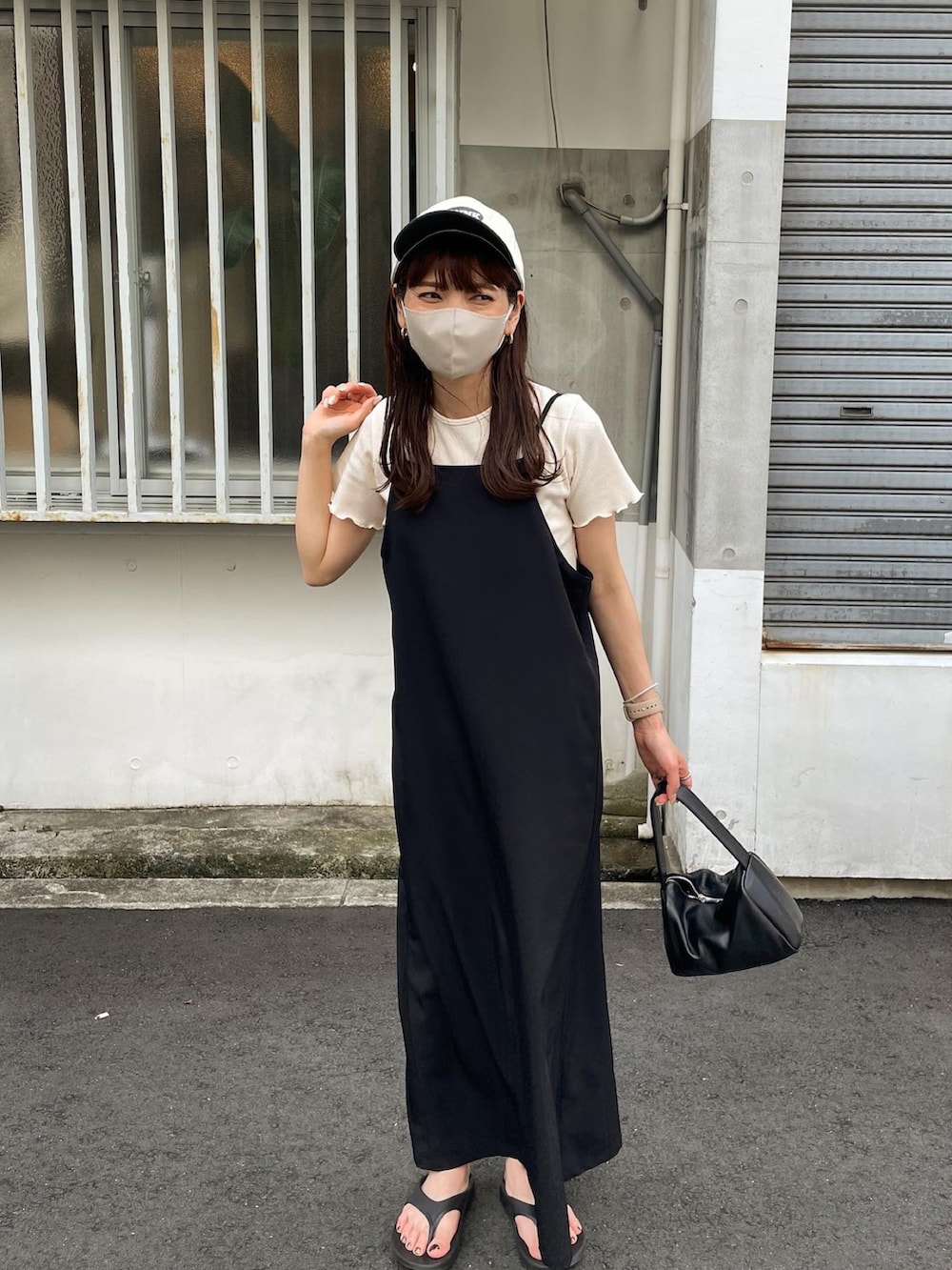 ホワイト系のTシャツ/カットソー、ブラック系のワンピース、ブラック系のサンダルを着用したレディースの夏コーディネートの3枚目の写真