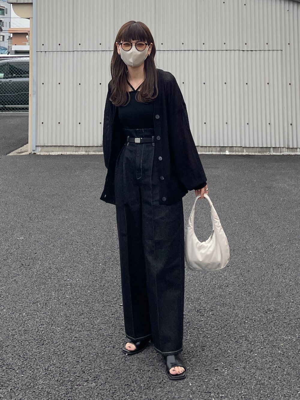 ブラック系のカーディガン/ボレロ、ブラック系のデニムパンツ、ホワイト系のハンドバッグを着用したレディースの春コーディネートの2枚目の写真