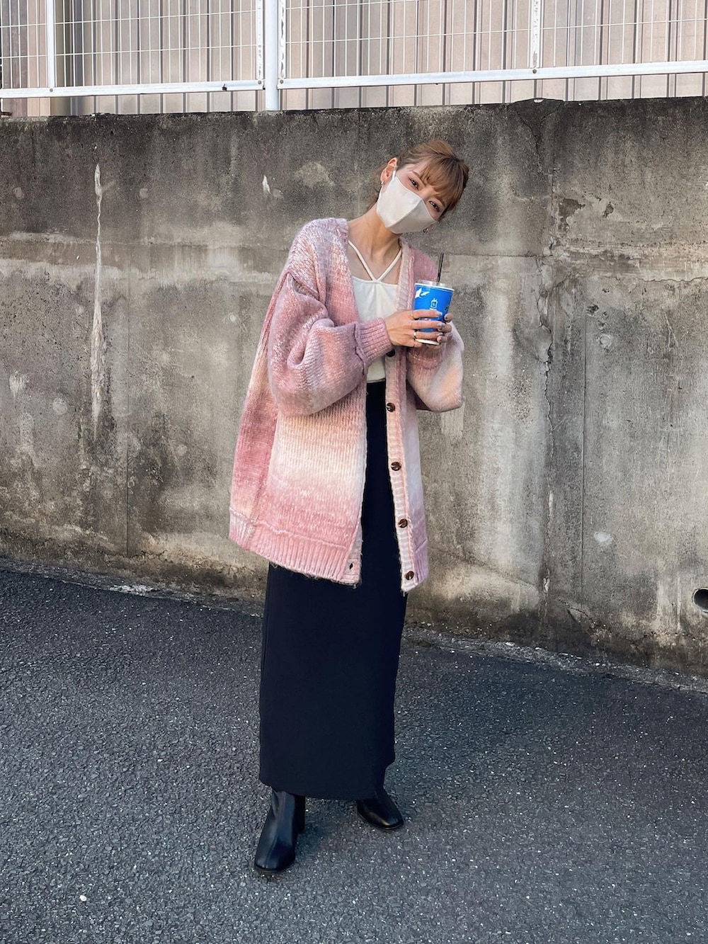 ピンク系のカーディガン/ボレロ、ブラック系のスカート、ホワイト系のキャミソールを着用したレディースの秋コーディネートの3枚目の写真