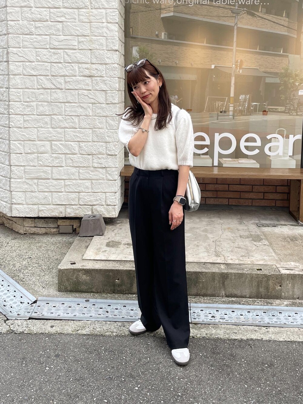 ホワイト系のニット/セーター、シルバー系のショルダーバッグ、ホワイト系のスニーカーを着用したレディースの秋コーディネートの2枚目の写真